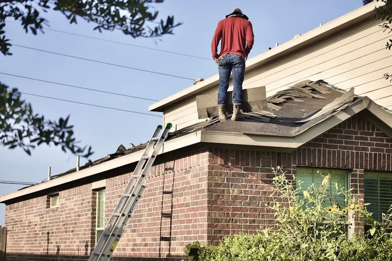 Professional roofer working on a residential roof in Westhollow
